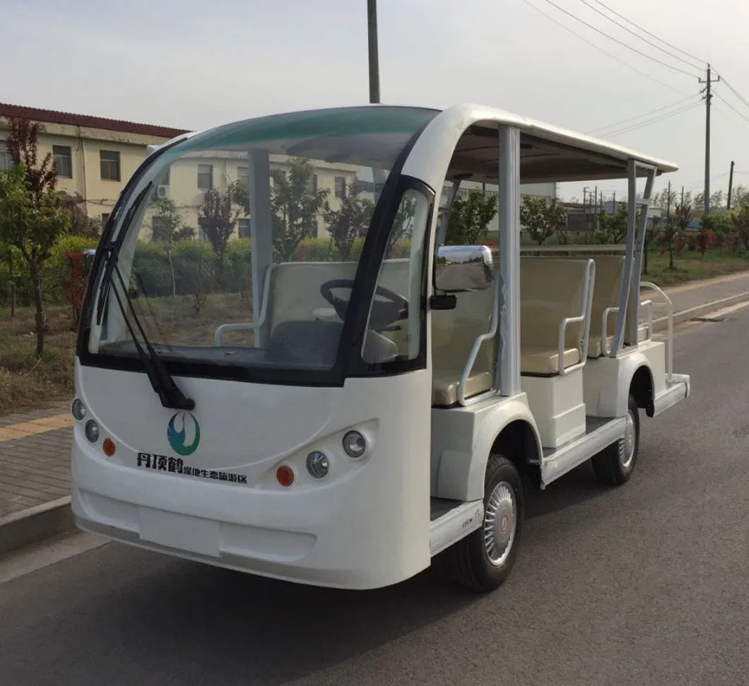 Small electric vehicle on a road with buildings and trees in the background