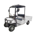 ocean cartz three-quarter front studio shot of a white utility electric vehicle with a short flatbed, set against a pure white background. This two-seater electric work cart features a black roof, black seats, a robust black front brush guard, and a small windshield with a wiper. The electric utility truck has custom silver alloy wheels and is designed for commercial hauling and property maintenance tasks.