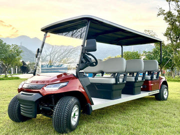 Golf cart on a grassy area with mountains in the background