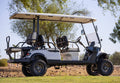 Golf cart on a grassy area with trees in the background