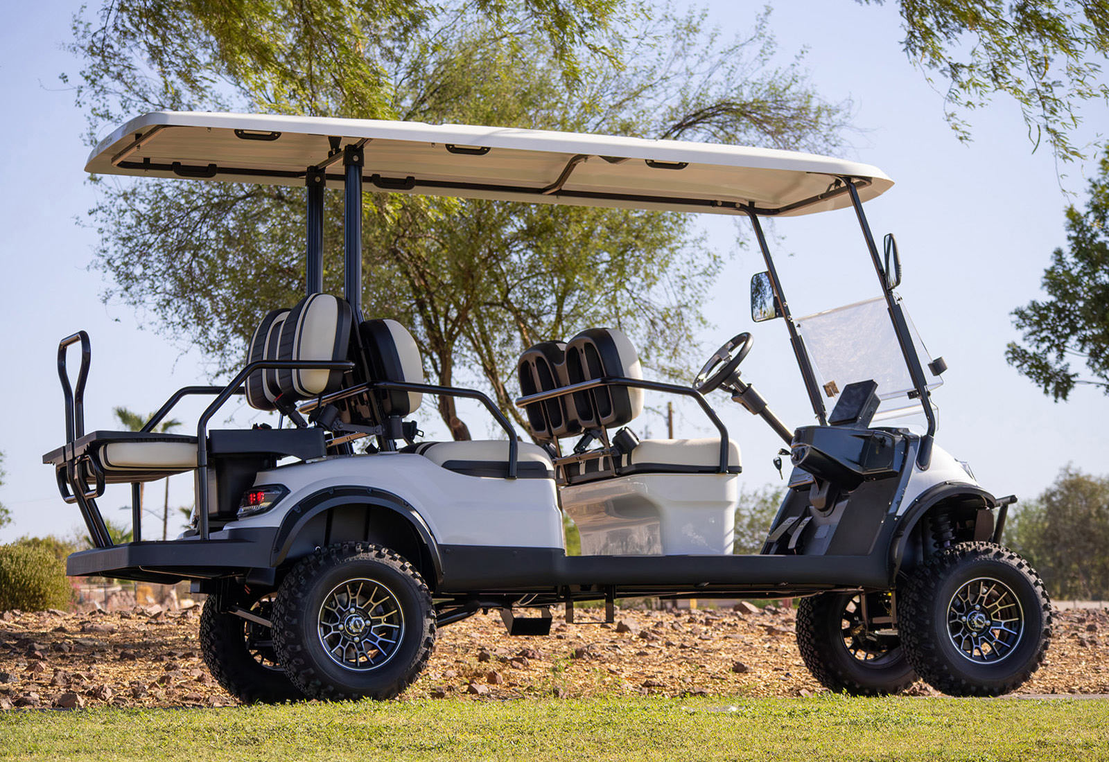Golf cart on a grassy area with trees in the background