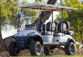White golf cart with black seats in a natural setting
