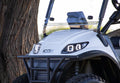 Close-up of a white UTV with 'Icon' branding, parked next to a tree.