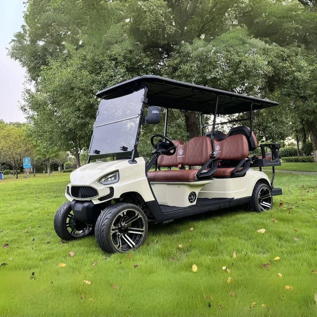 Golf cart on grass with trees in the background
