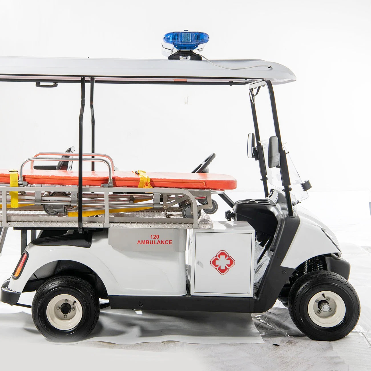 Model of an ambulance golf cart with a stretcher on a white background