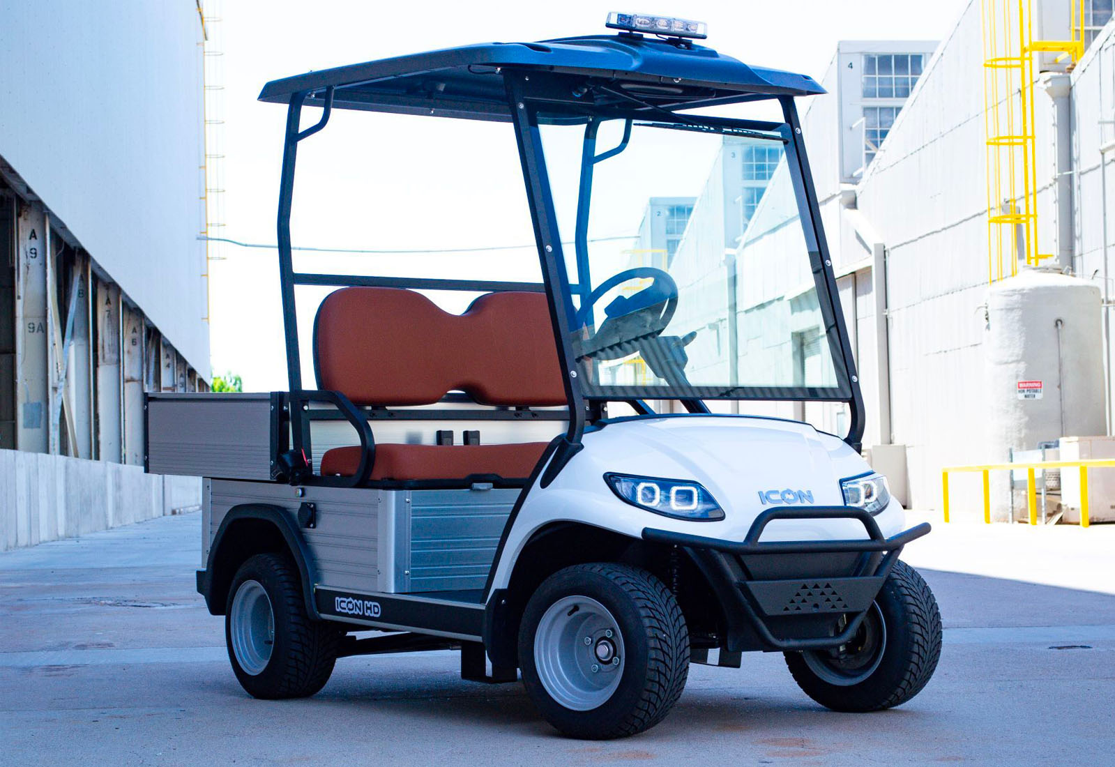 White golf cart with a blue canopy in an urban setting