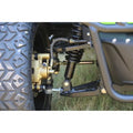 Close-up of a motorcycle suspension system with a tire and grass background