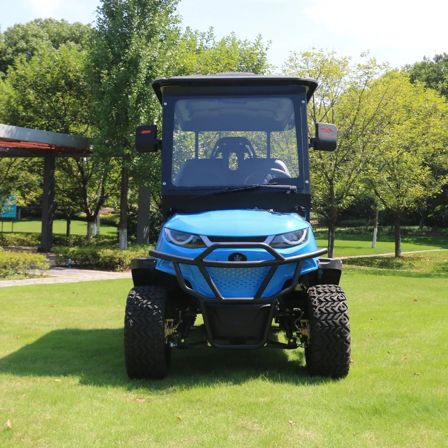 Blue utility vehicle on a grassy area with trees in the background
