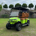 Green golf cart with brown seats on a grassy area with trees in the background