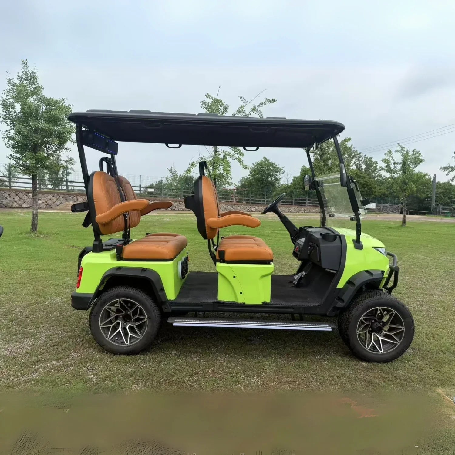 Green golf cart with brown seats on a grassy area